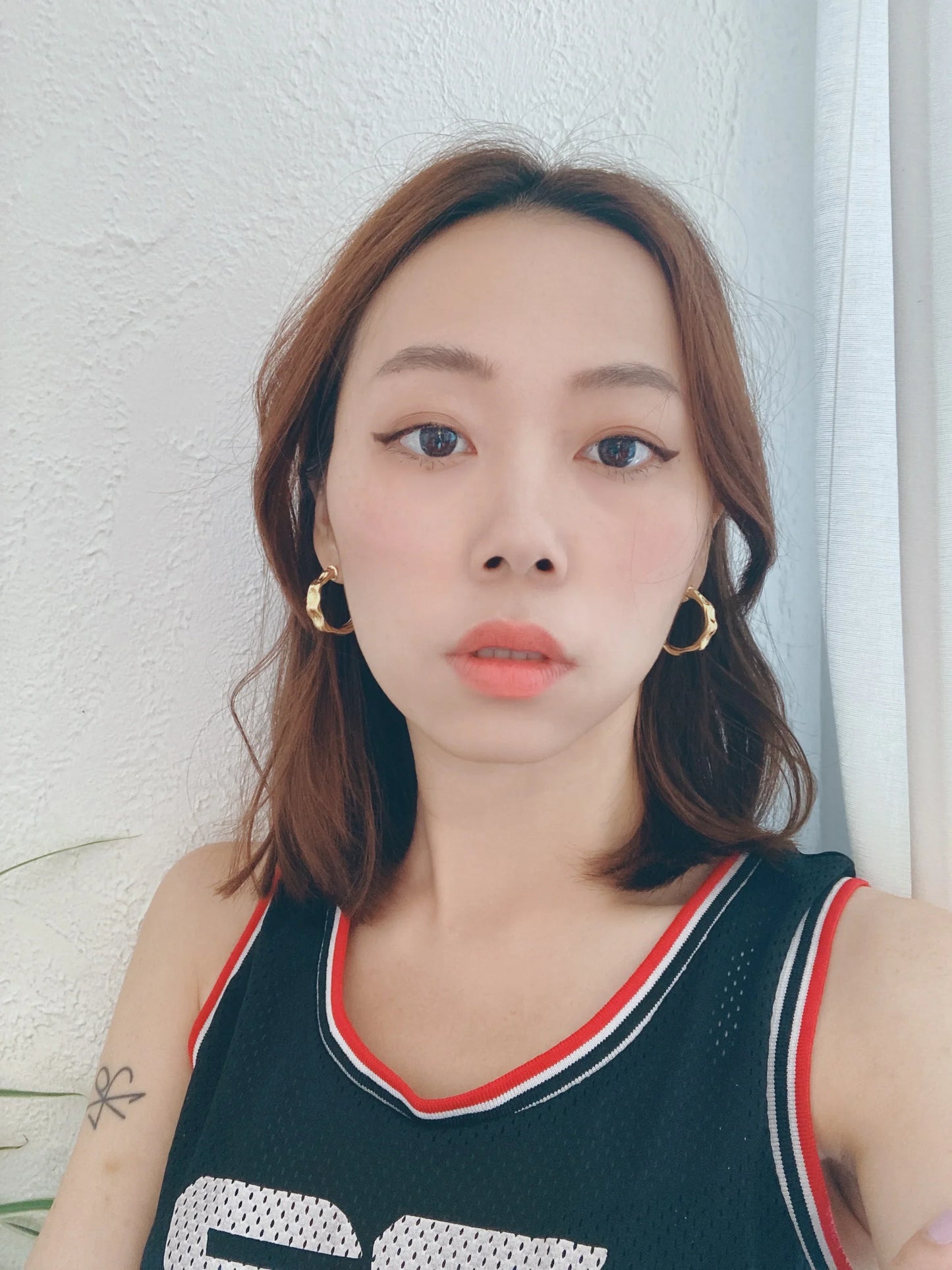 Woman wearing chunky 18K gold plated 925 silver hoop earrings, modern jewelry style